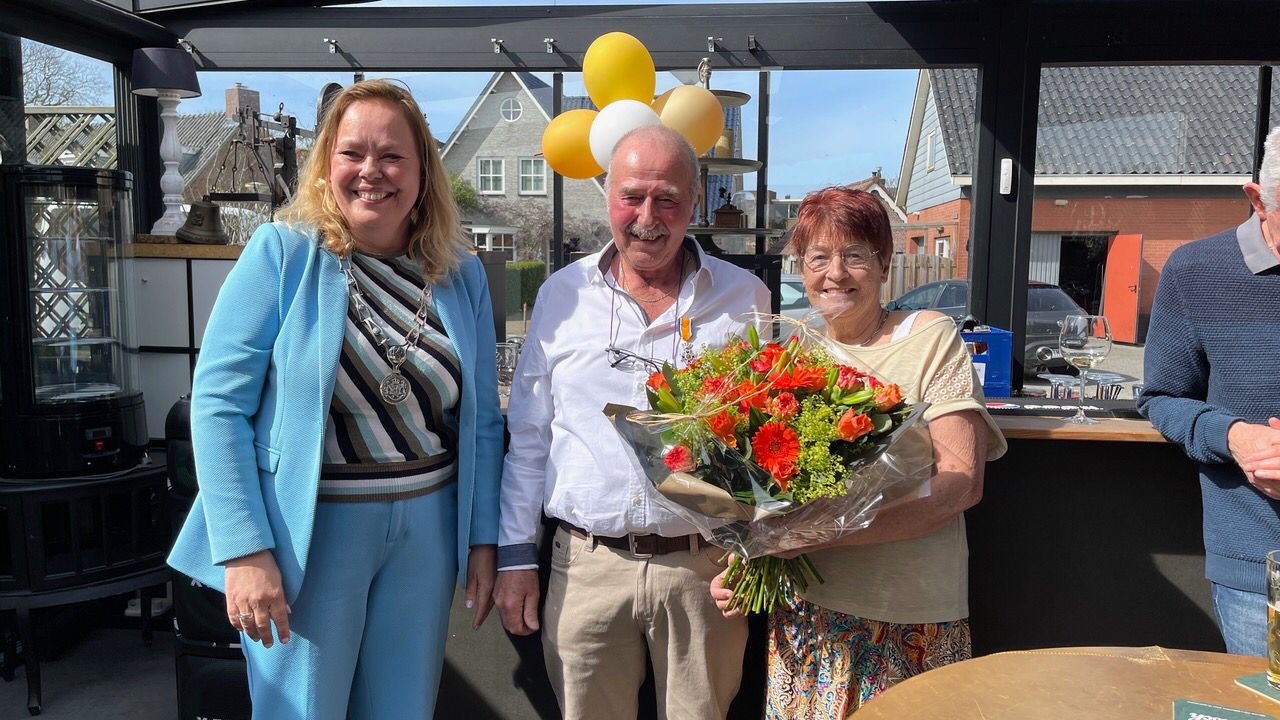 Burgemeester Astrid Heijstee-Bolt, samen met Arie van der Pouw Kraan en zijn vrouw met het lintje en bloemen. 